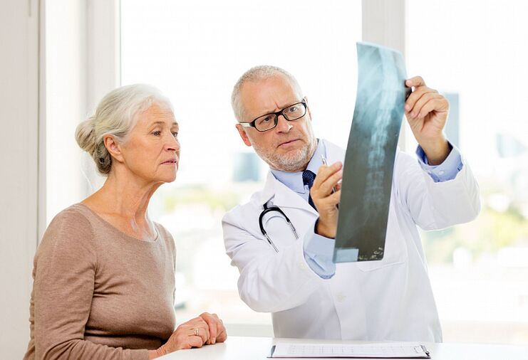 Le médecin diagnostique l'ostéochondrose cervicale chez un patient à l'aide d'une radiographie